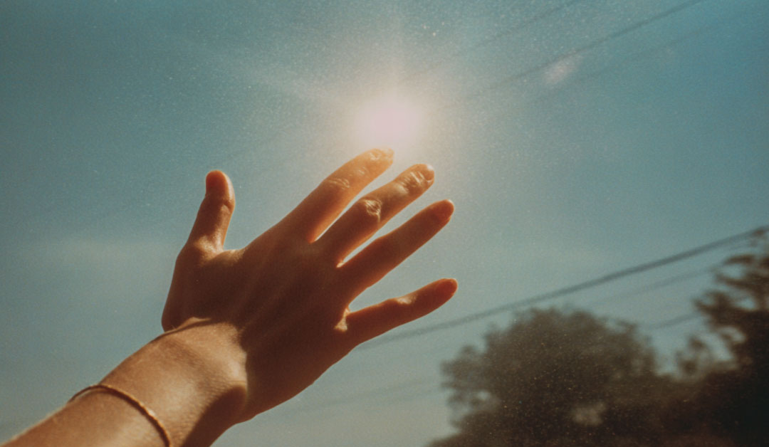 Une main en l'air en direction du ciel ensoleillé