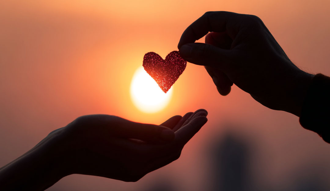 Une main qui offre un coeur à une autre main, tel un amour commandé